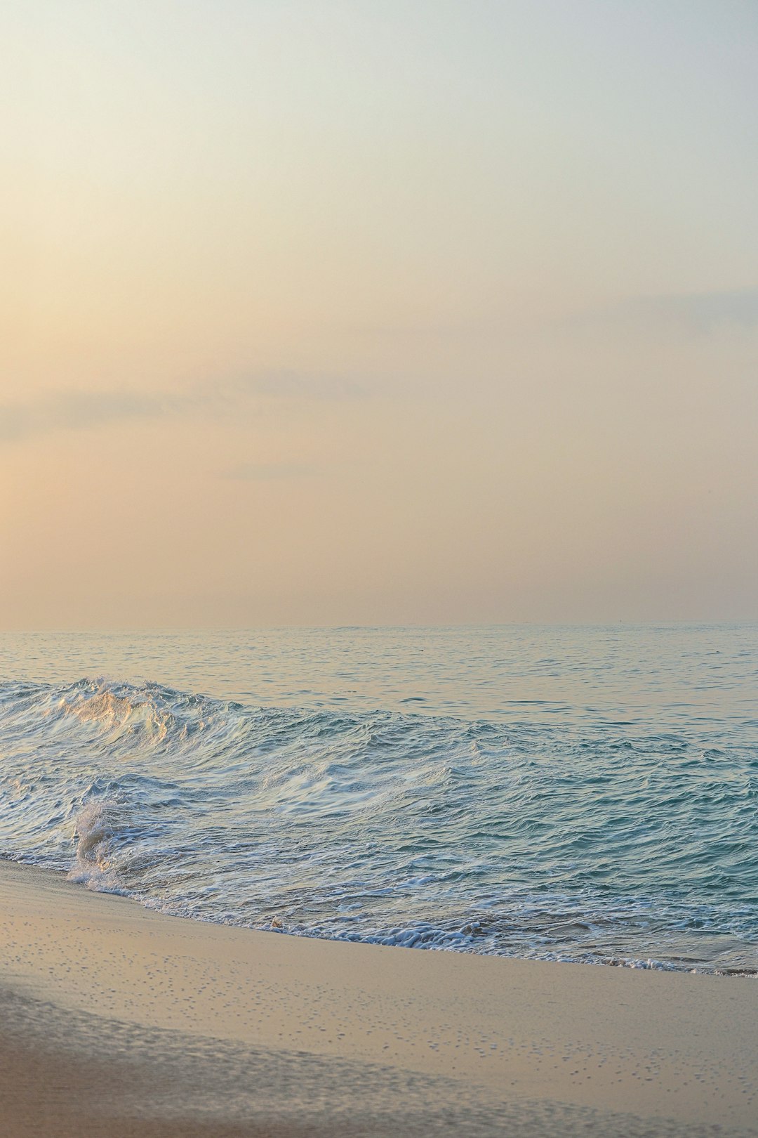 a person walking on the beach with a surfboard